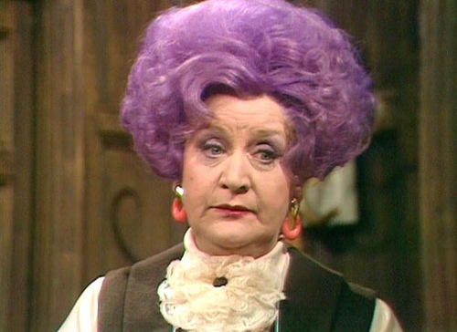 Mollie Sugden as Mrs Slocombe